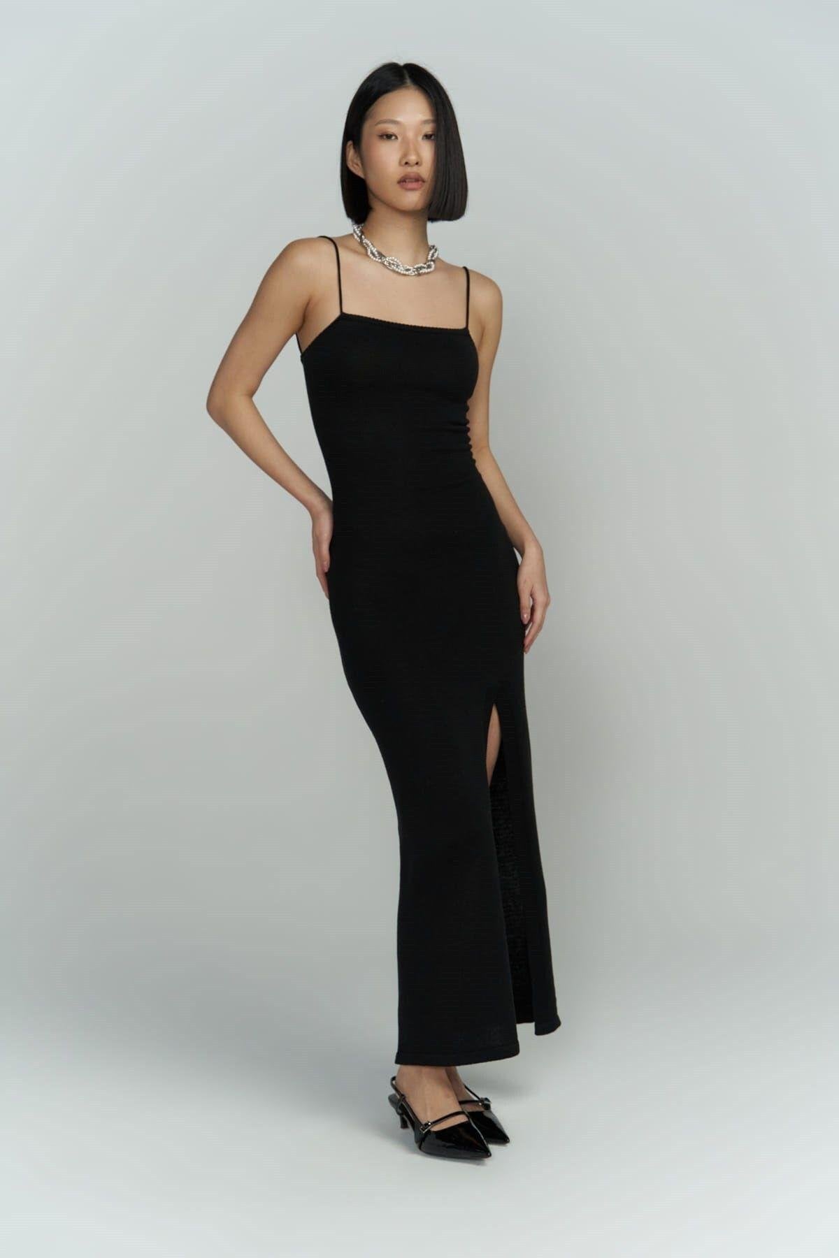Full-length photo of black ribbed knit dress on model, showing slim fit and textured knit