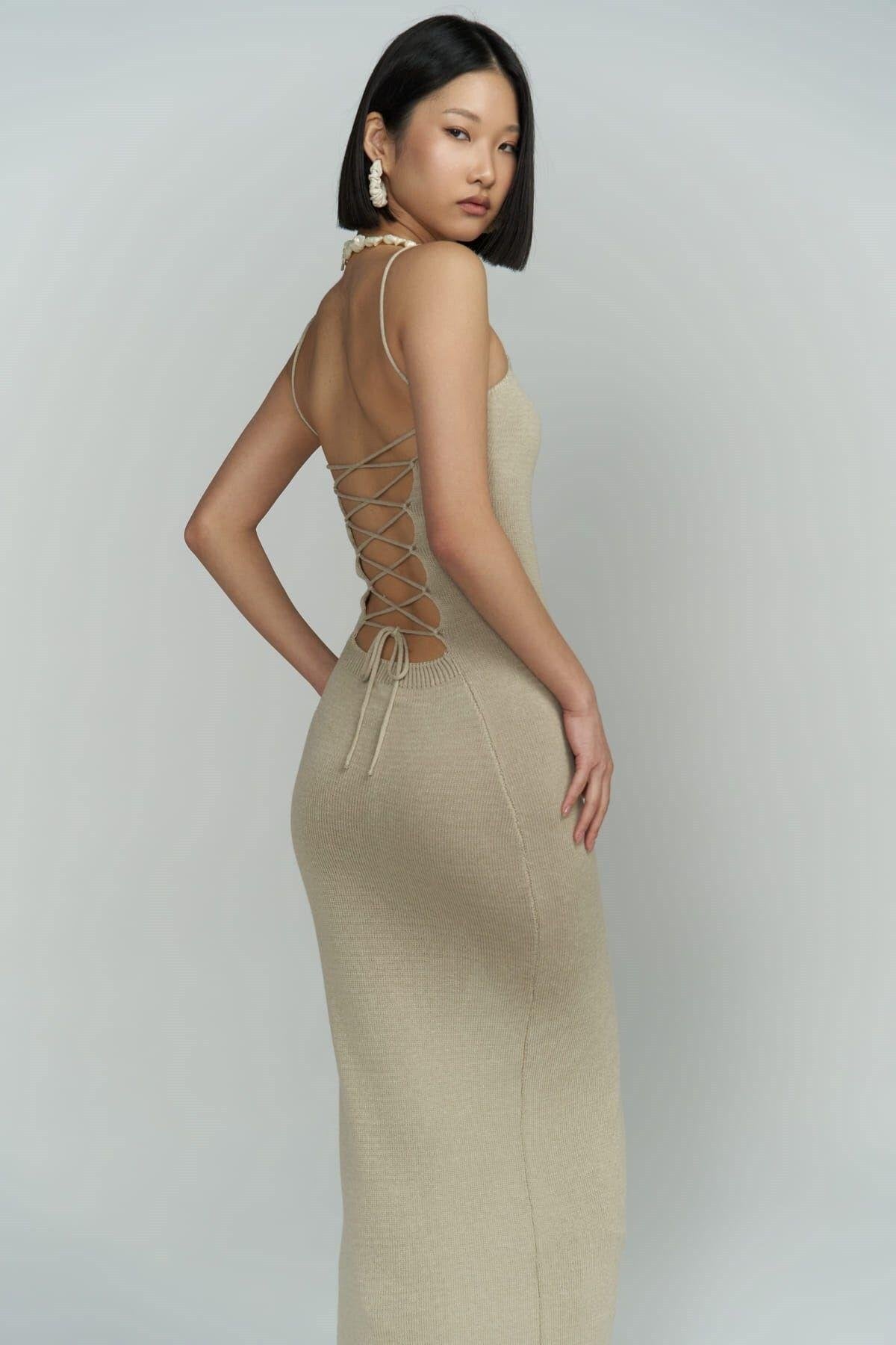 Back view of the beige backless knit dress, styled with nude heels – SHAÉN summer collection