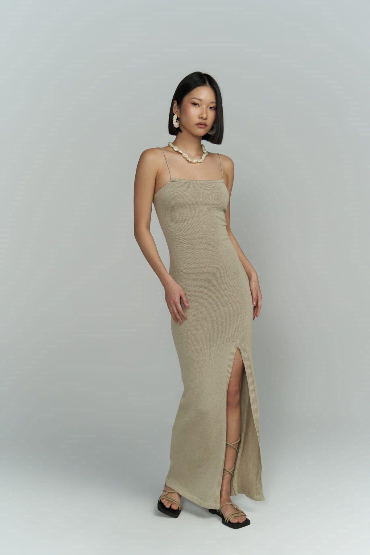 Full-length photo of beige ribbed knit dress on model, showing slim fit and textured knit