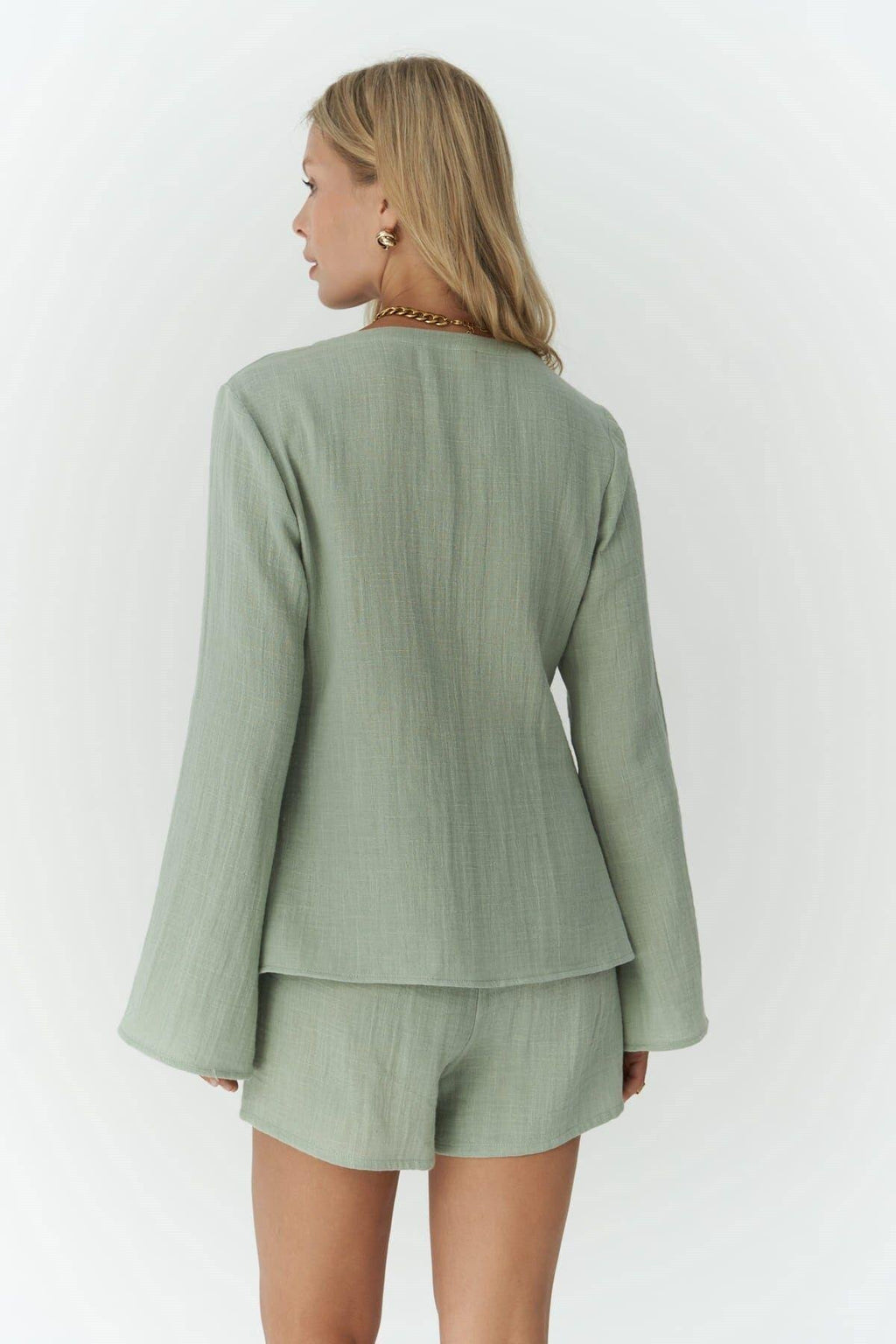 Woman wearing light sage cotton shirt and shorts set