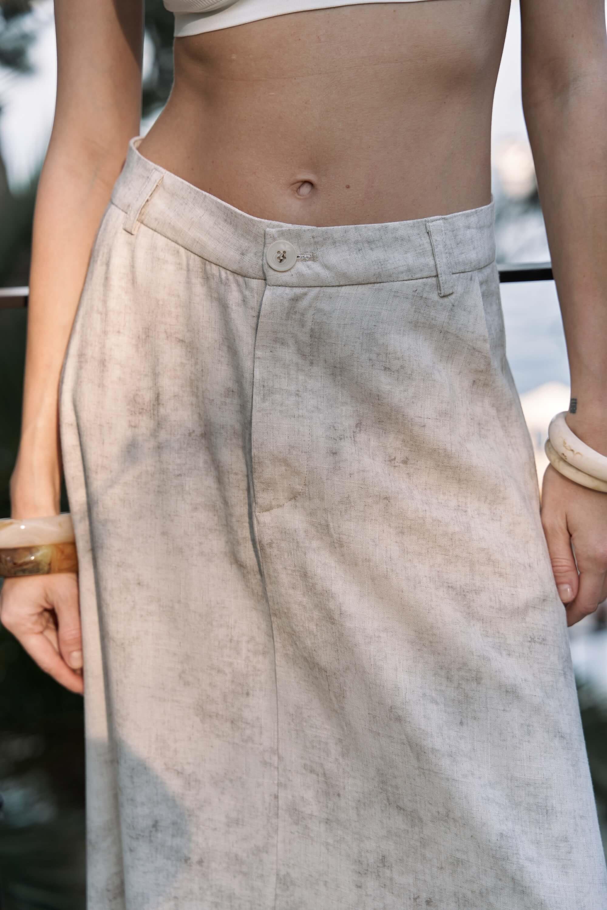 Person wearing a light-colored batik maxi skirt with a blurred background