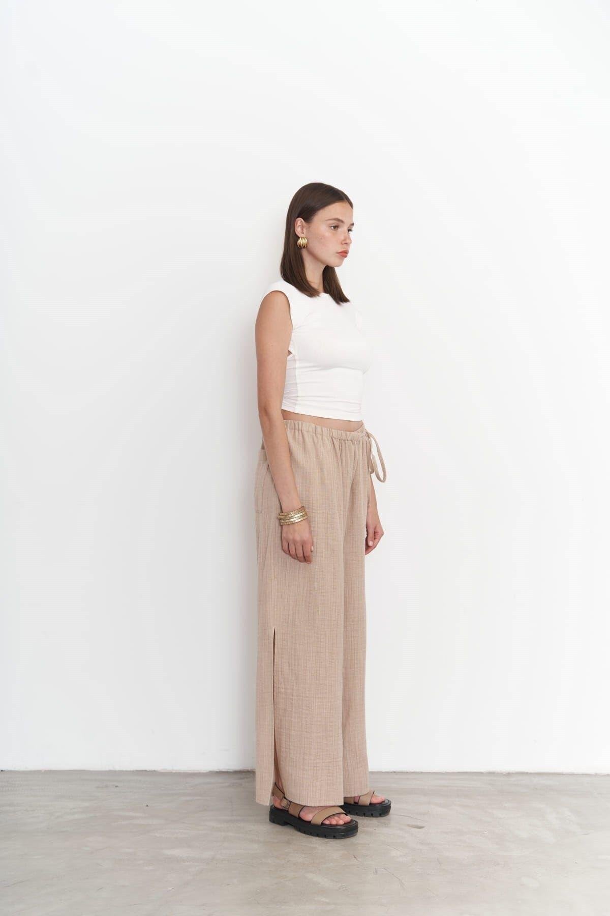 Full-length view of SHAÉN's breezy summer pants in neutral tones