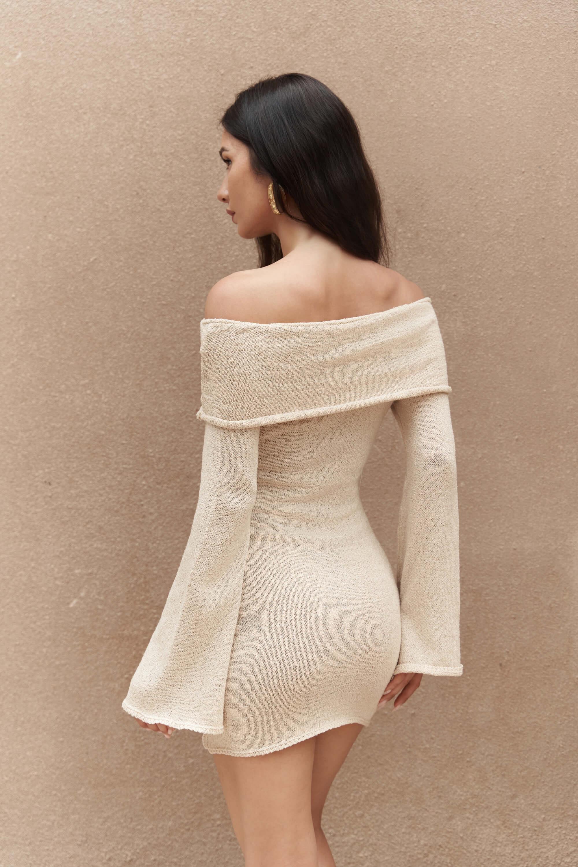 Woman wearing beige off-shoulder knit mini dress with wide sleeves