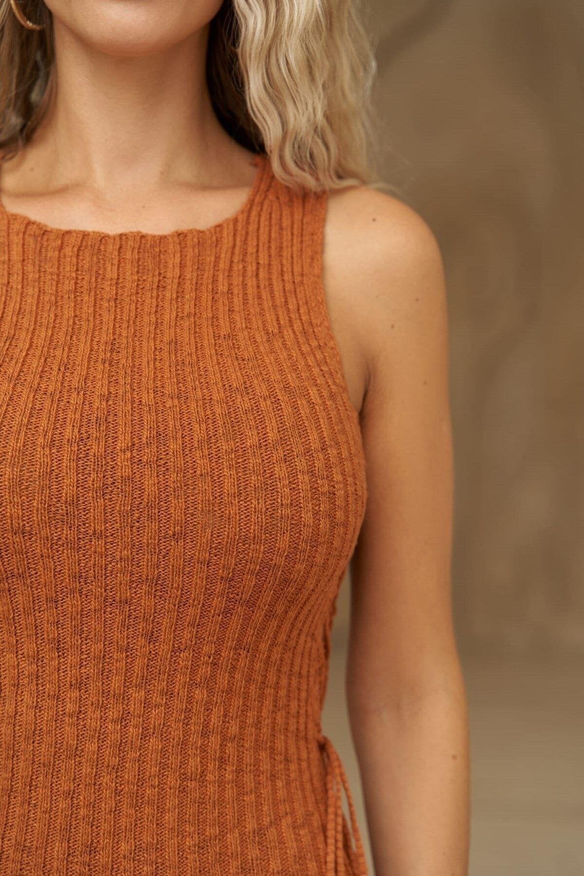 Close-up detail of side lace-up on sleeveless mini dress