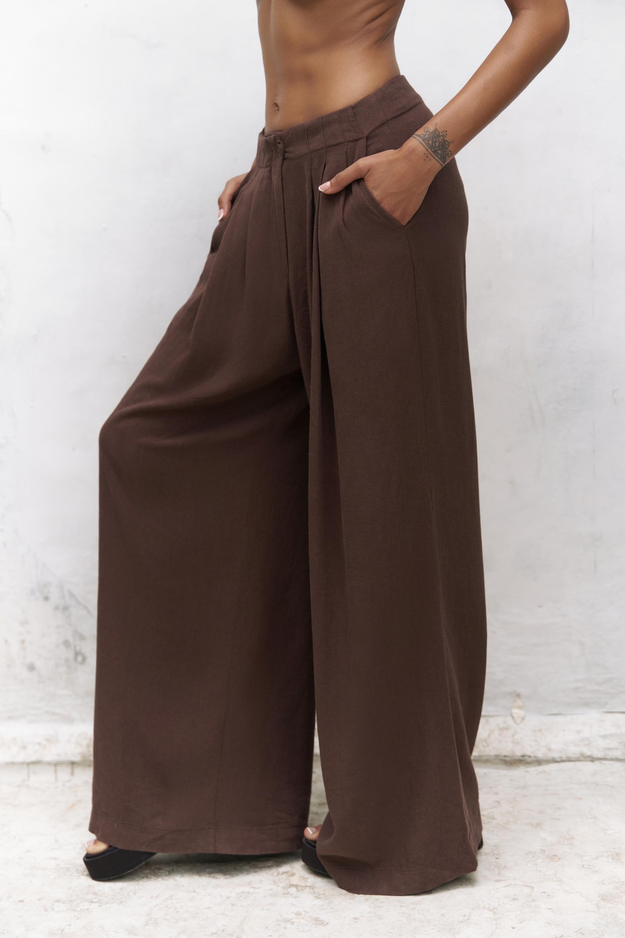 Brown wide-leg pants worn by a person against a white background