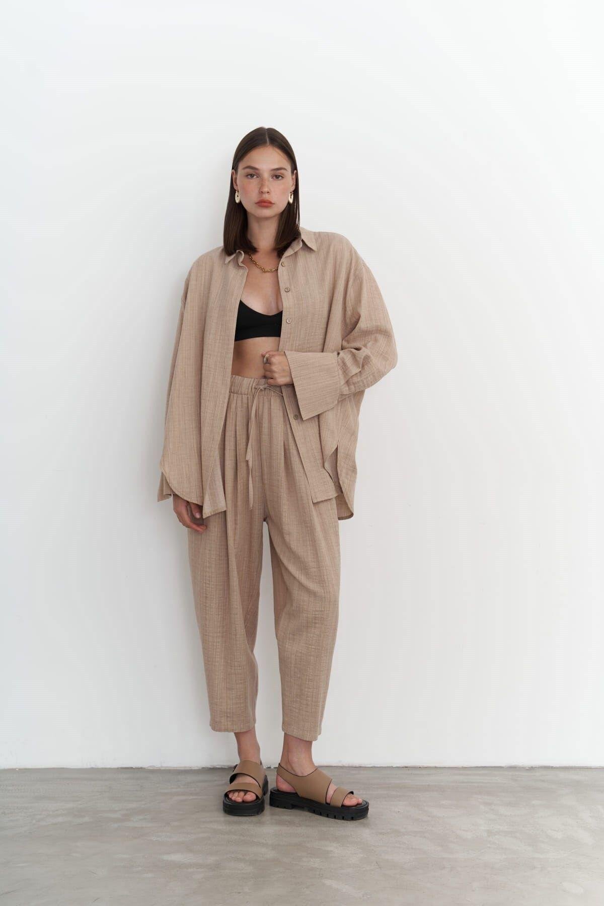 Woman wearing a beige outfit against a white background